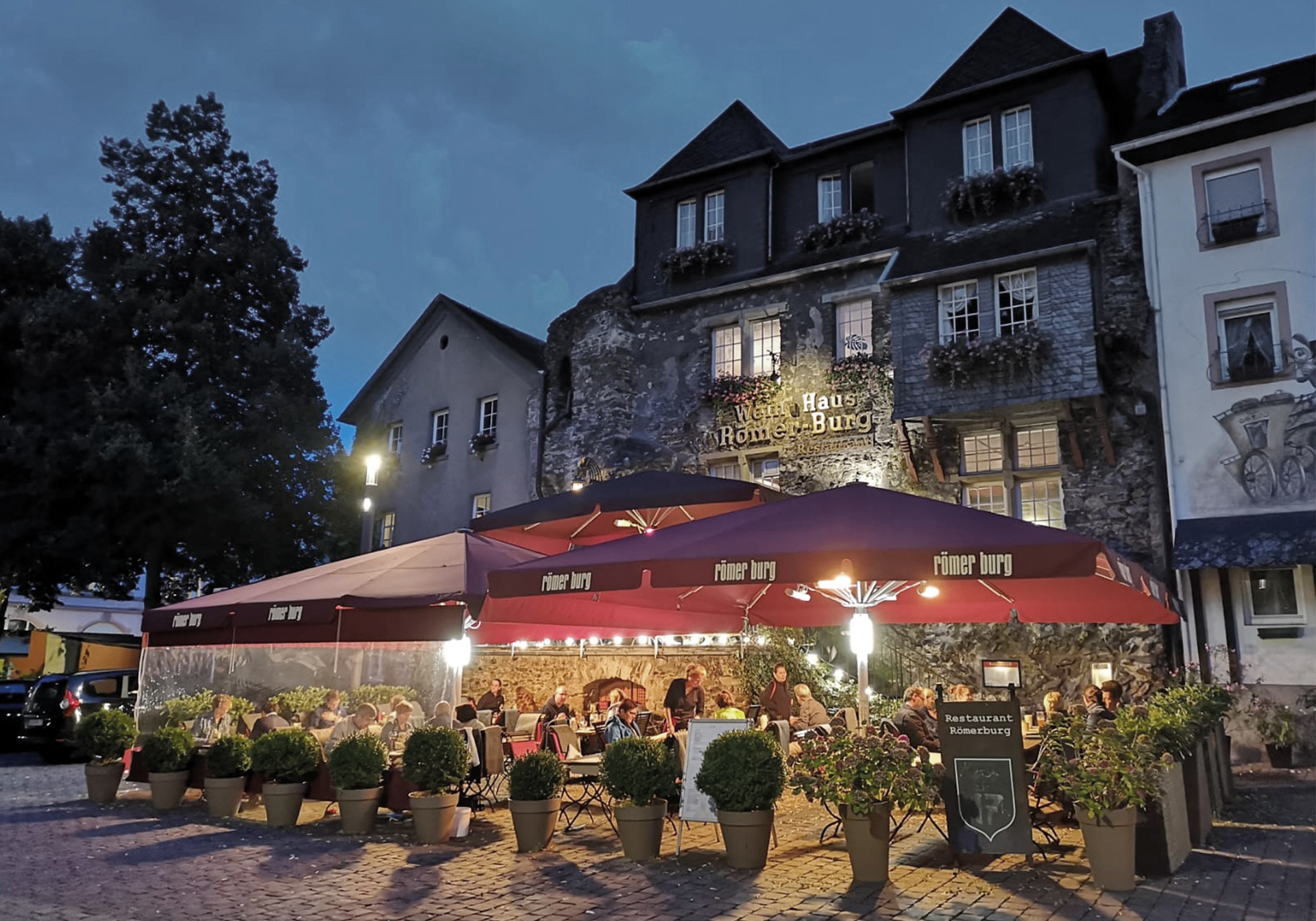 Blick auf die Roemerburg mit Außensitzplätzen